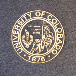 gold foil debossed college seal on blue leather